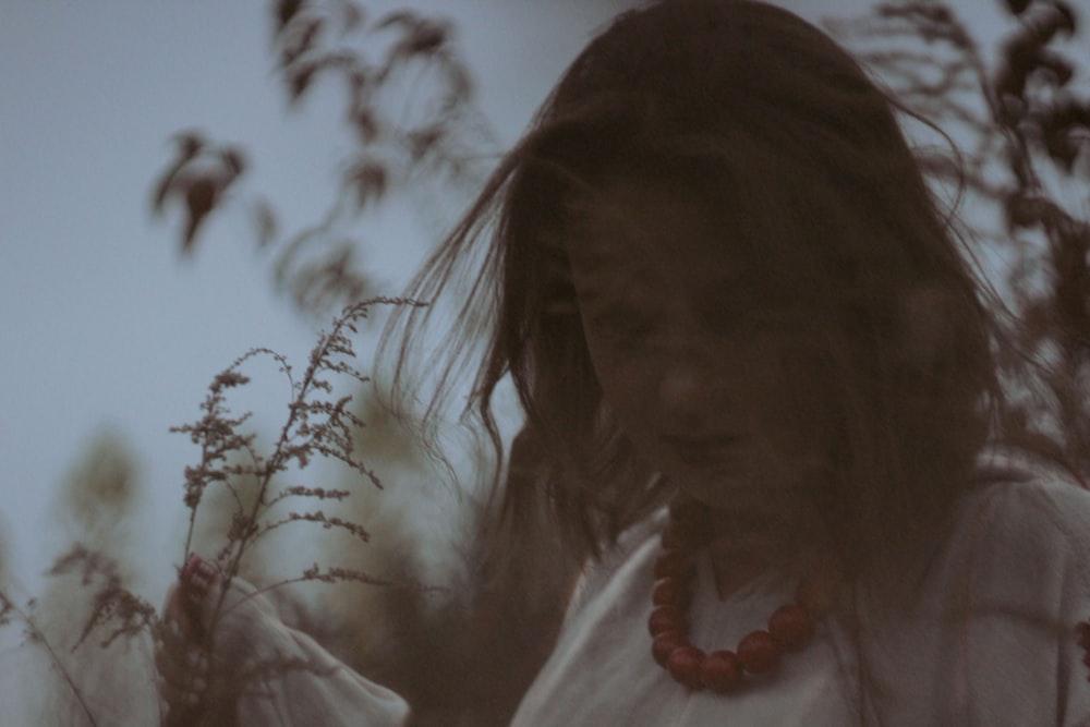 a woman standing in a field of tall grass