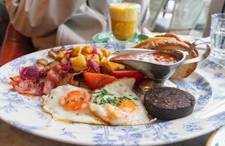 a blue and white plate topped with breakfast foods