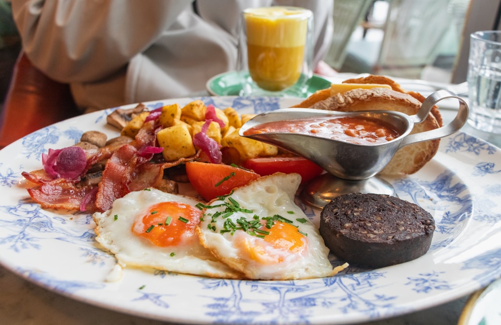 a blue and white plate topped with breakfast foods