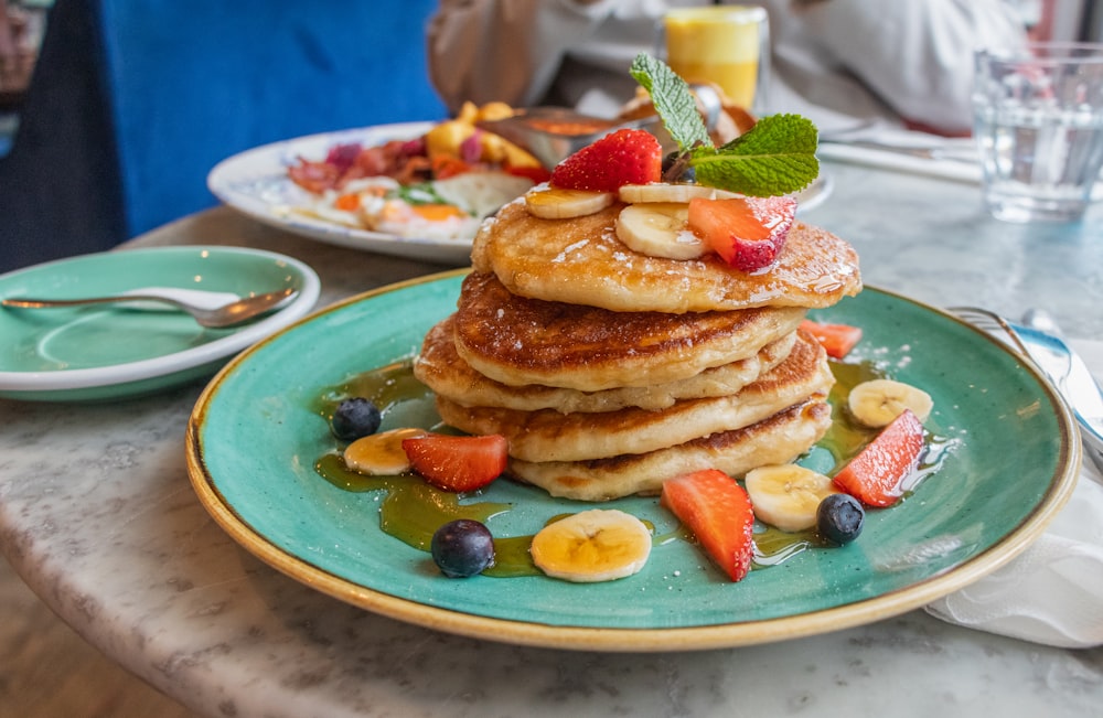 a stack of pancakes with fruit on top