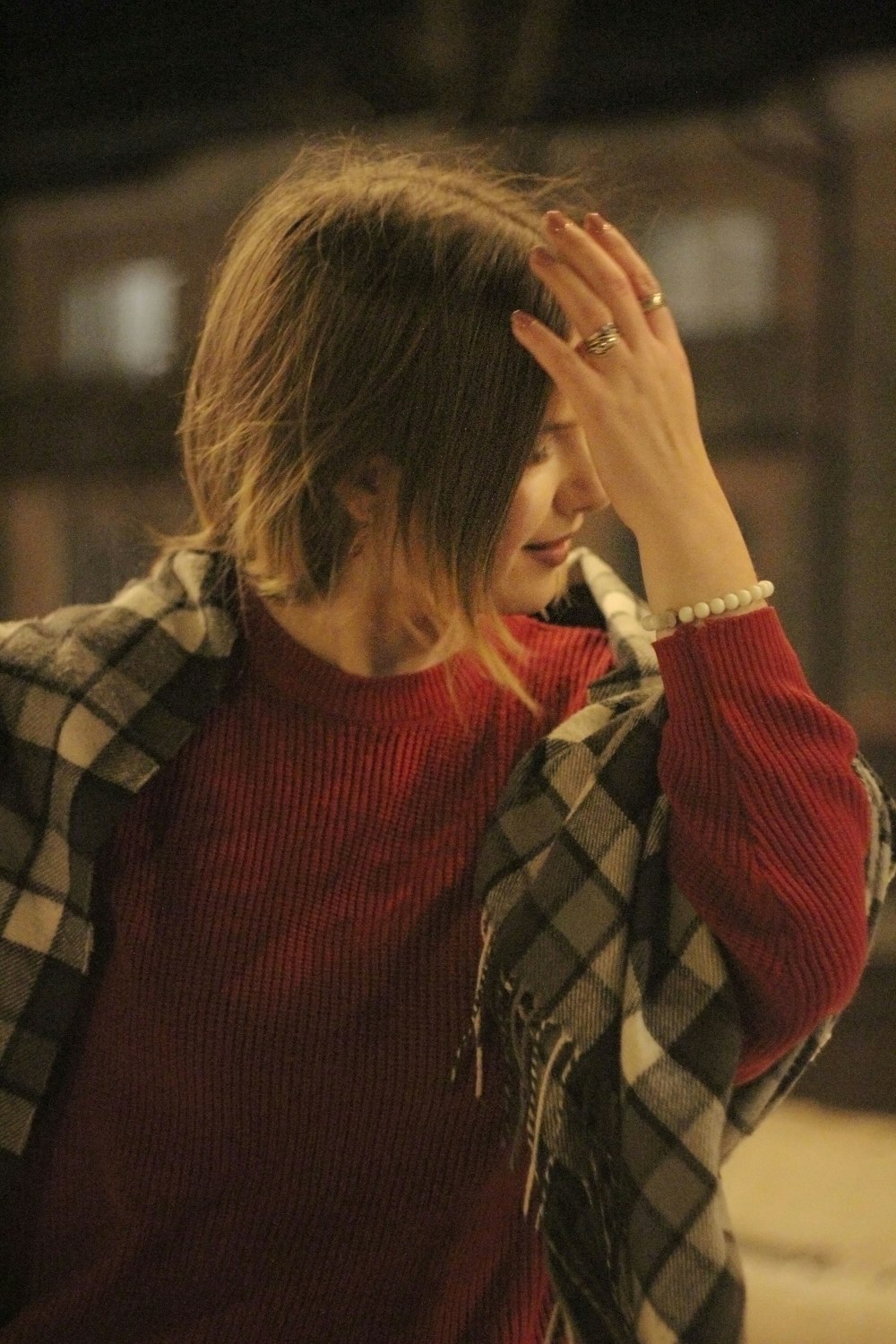 a woman in a red sweater is talking on a cell phone