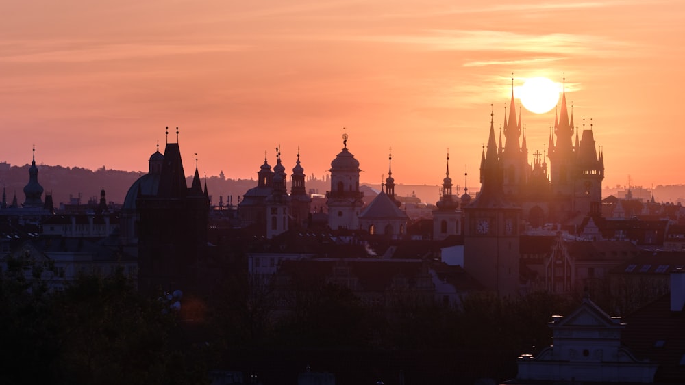 the sun is setting over a city with tall buildings