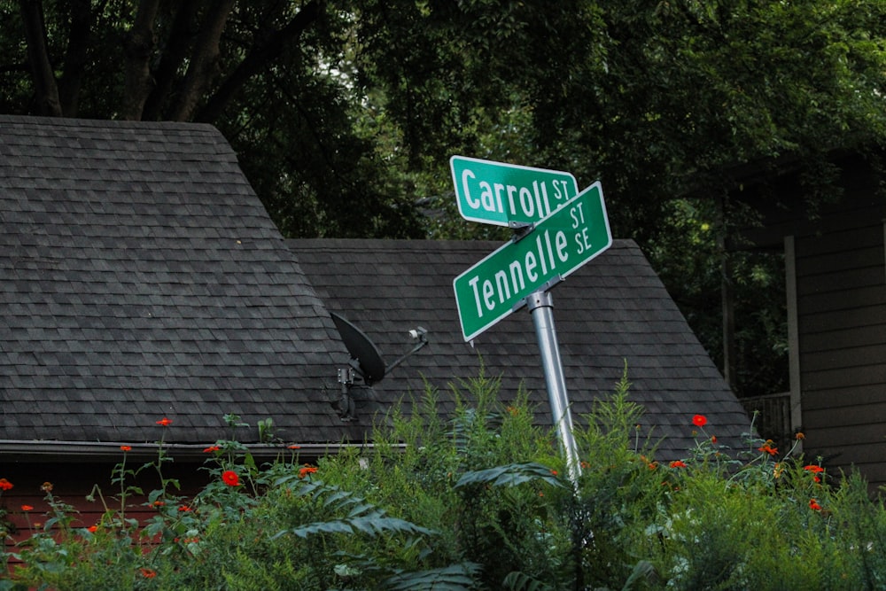 a couple of green street signs sitting on top of a metal pole