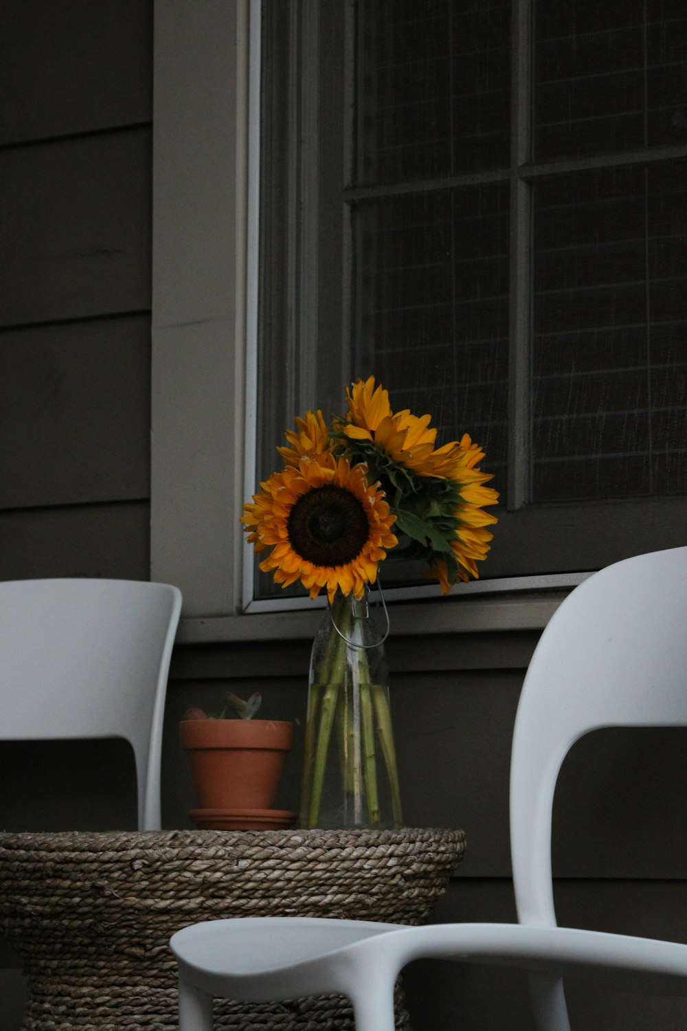 a vase of sunflowers sitting on a table in front of a window