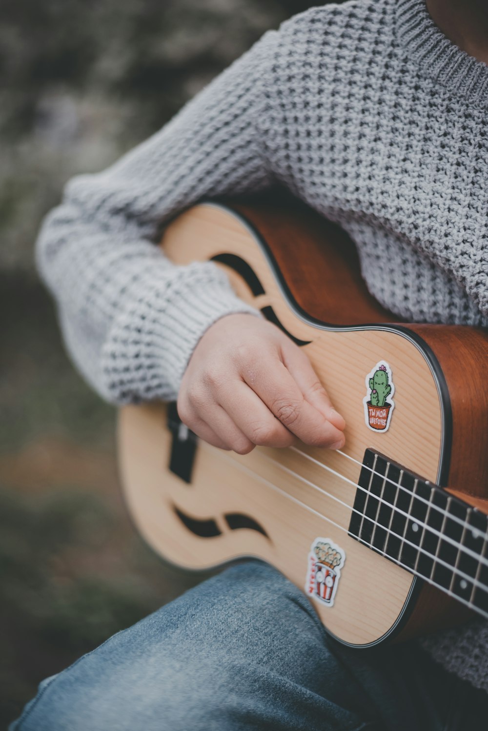 a person playing a ukulele with stickers on it