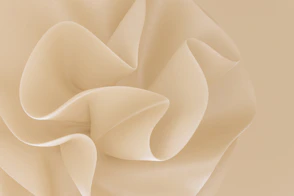 Smooth beige fabric folds creating soft abstract curves and shadows