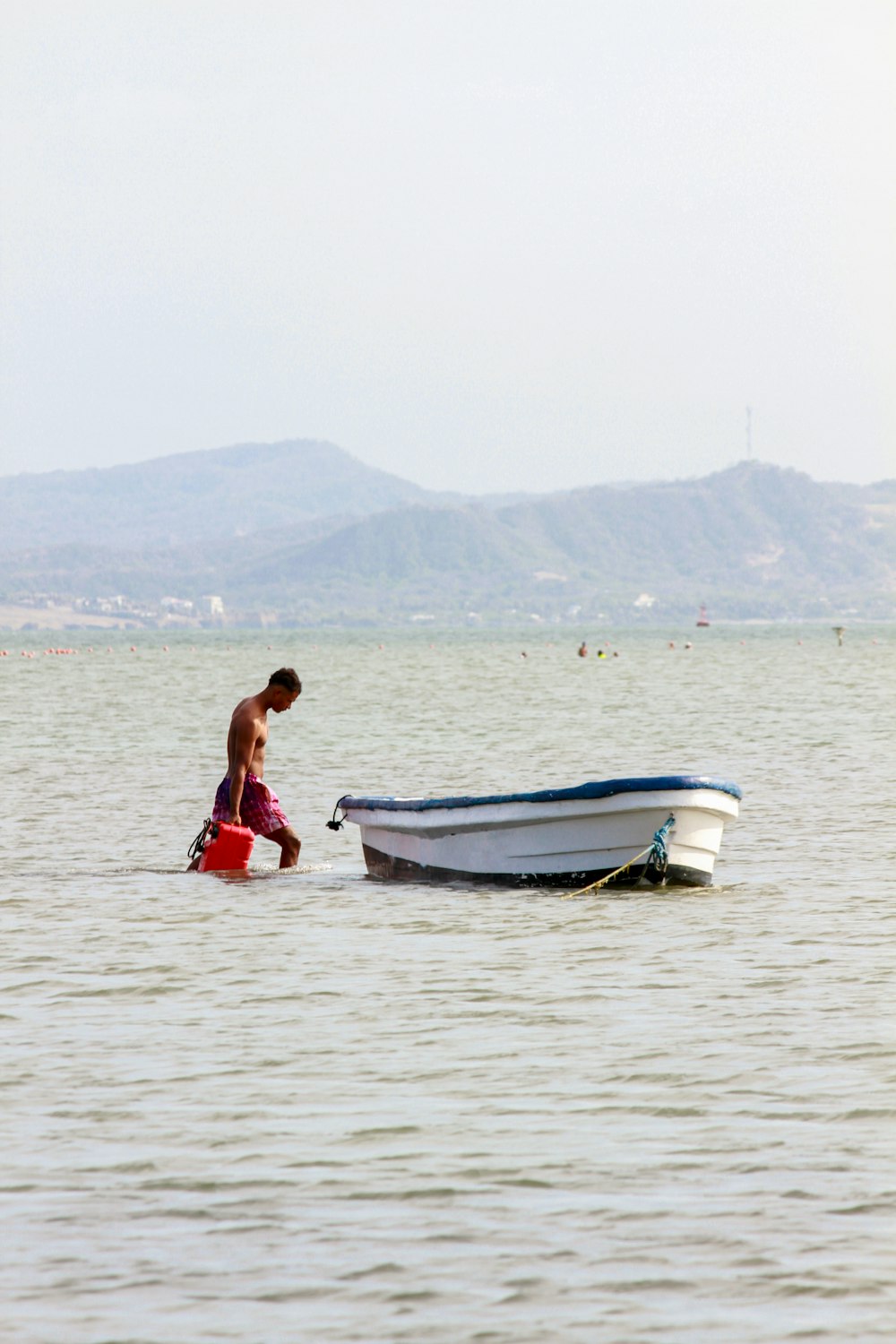 a man standing in the water next to a boat
