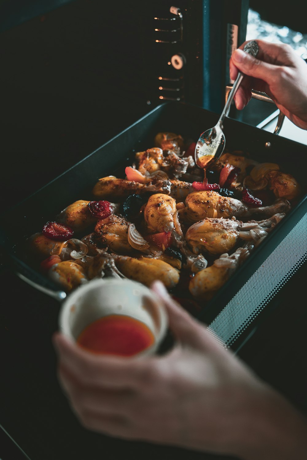 a person is spooning something into a pan of food