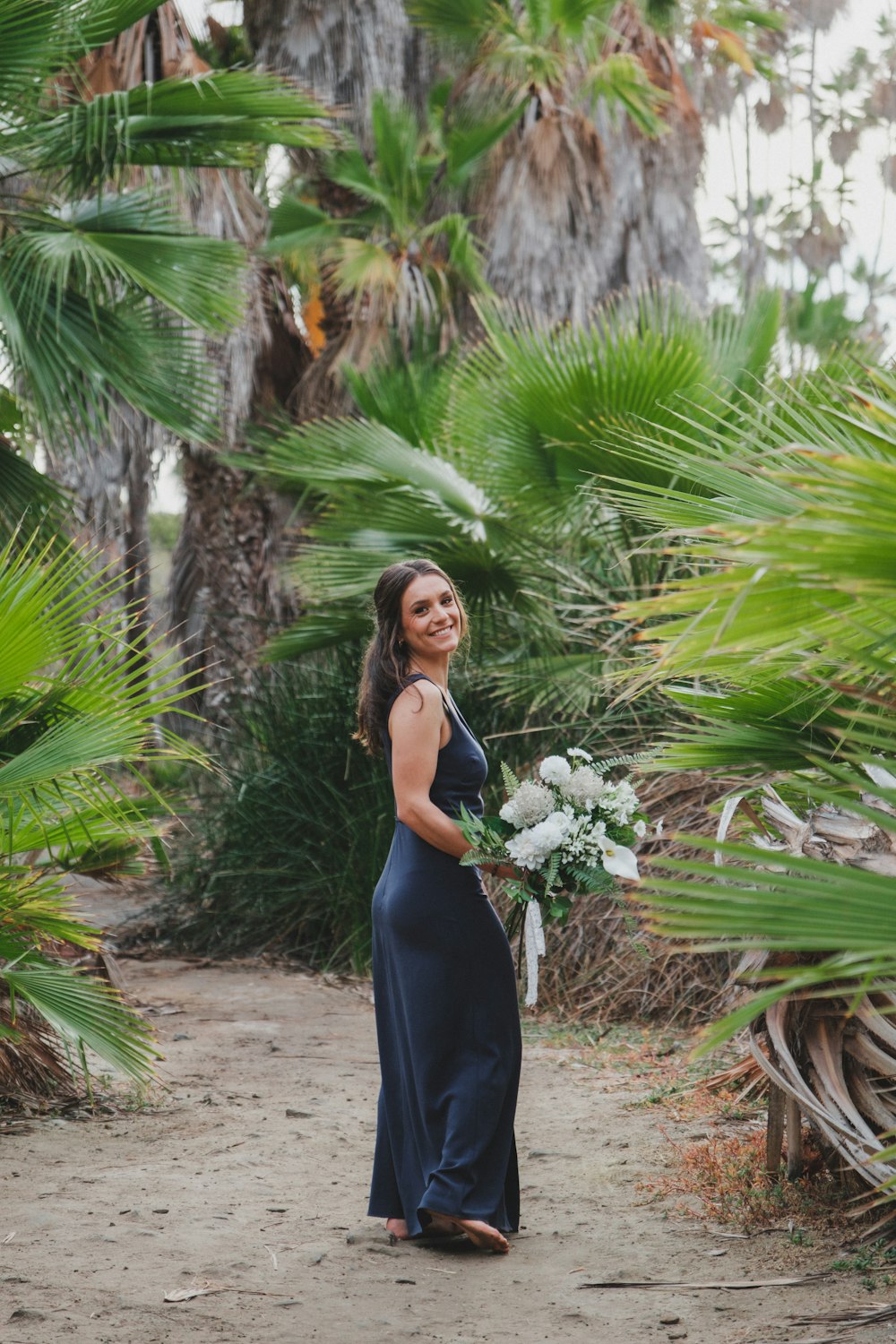 a woman in a blue dress holding a bouquet of flowers