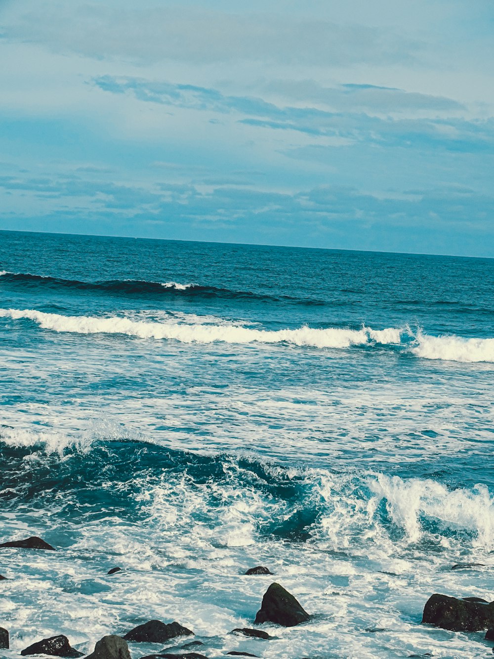 a man riding a surfboard on top of a wave in the ocean