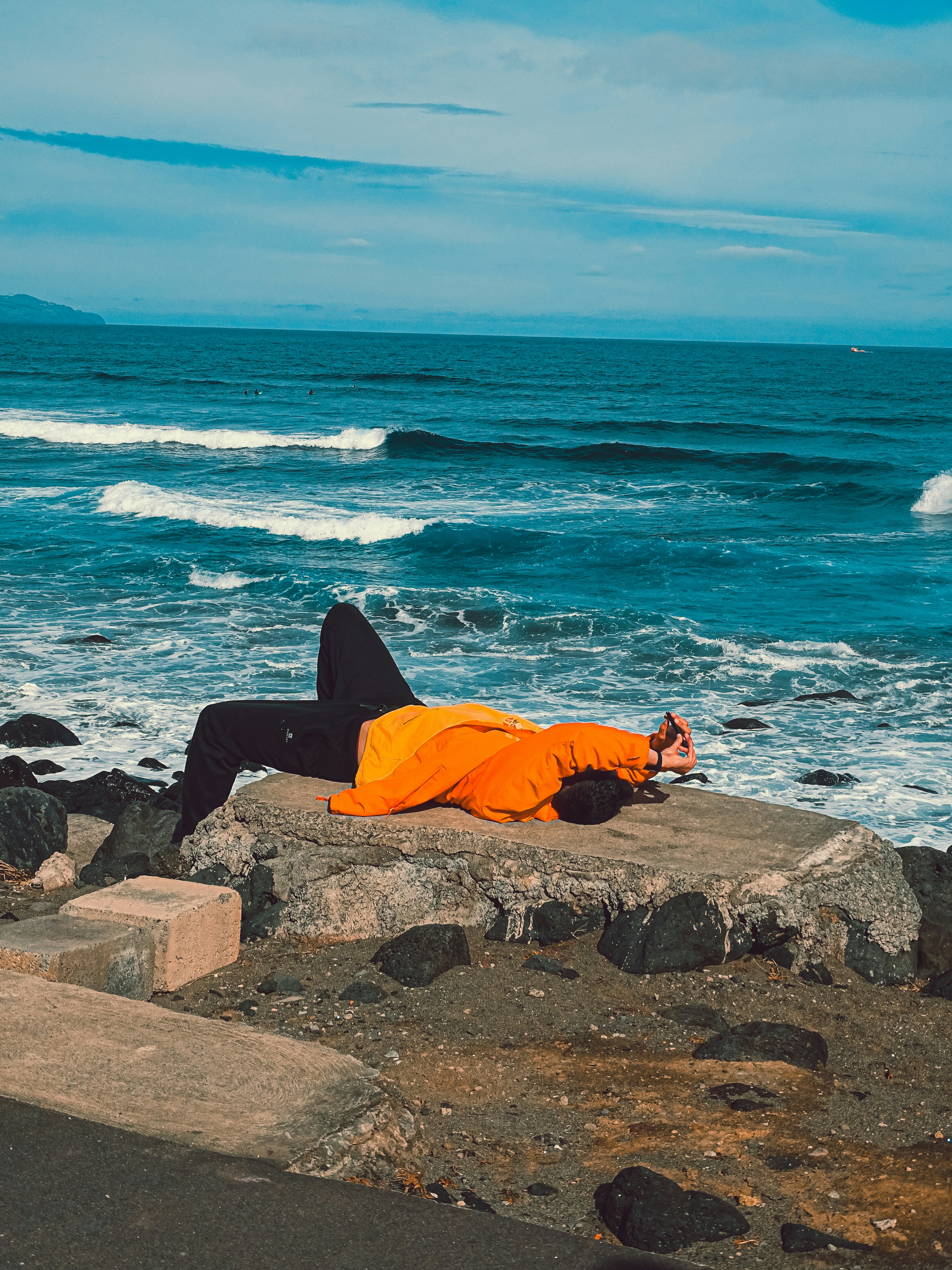 A person laying on a rock near the ocean photo – Free Portugal Image on ...