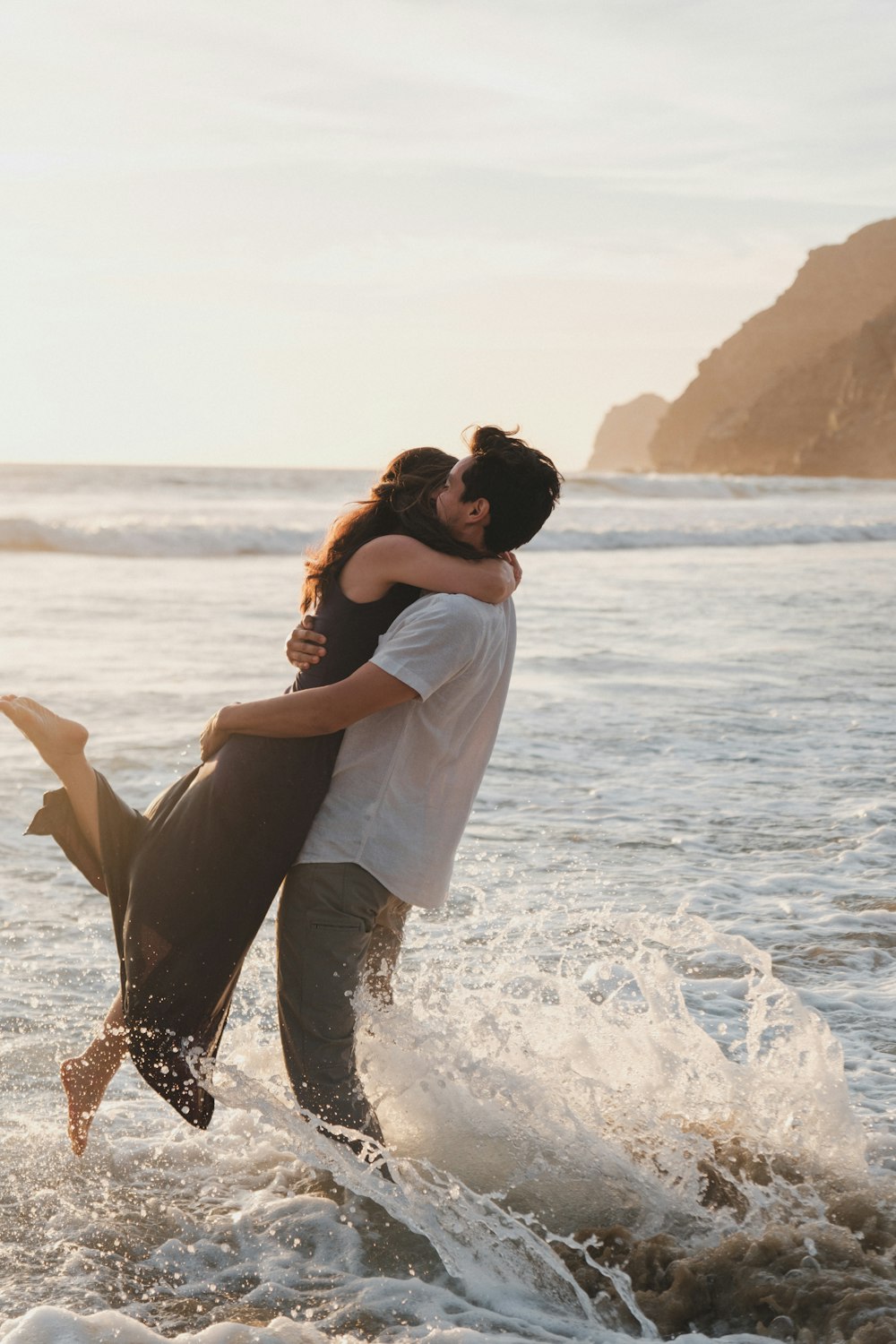 a man and a woman are hugging in the ocean