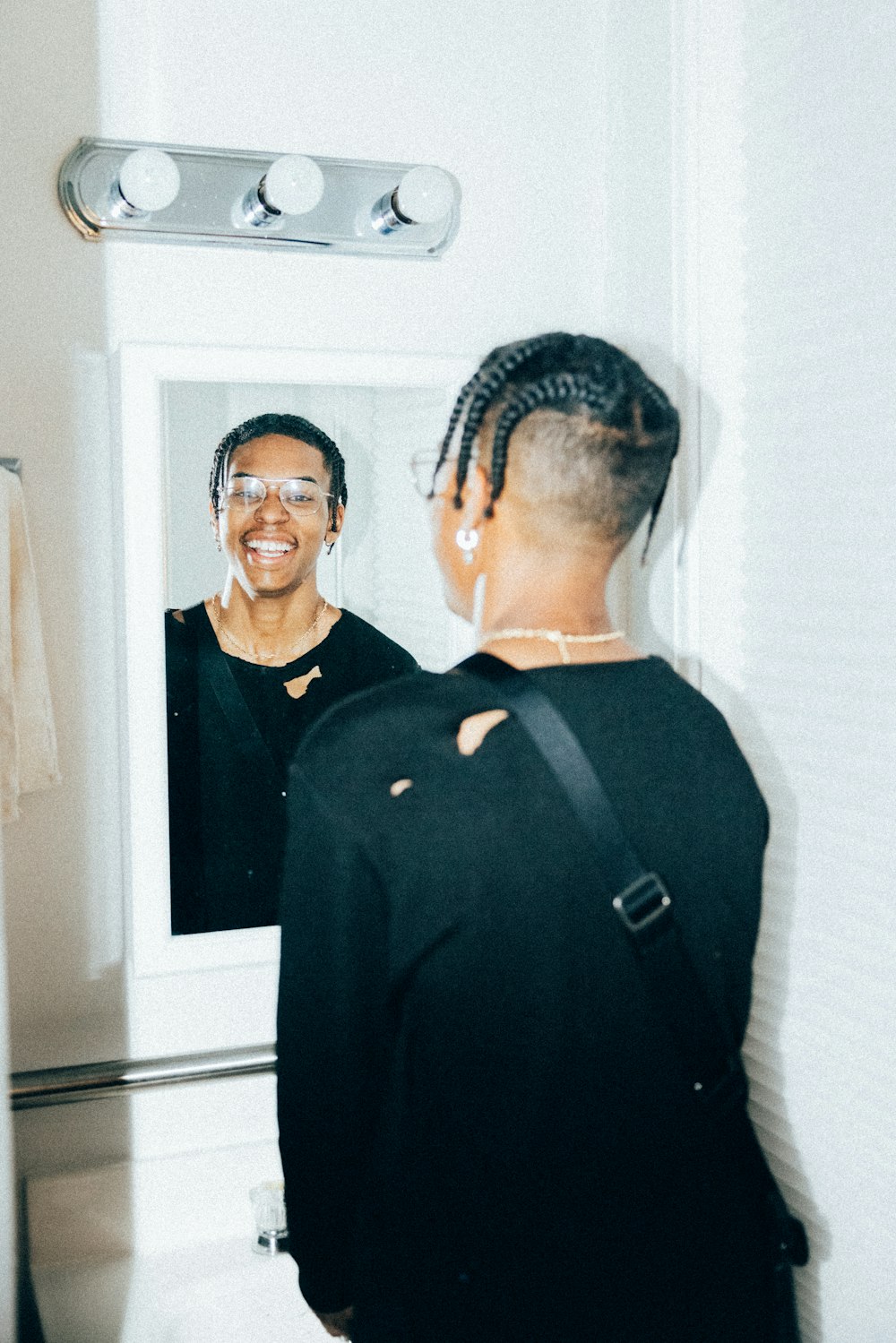 a woman standing in front of a bathroom mirror