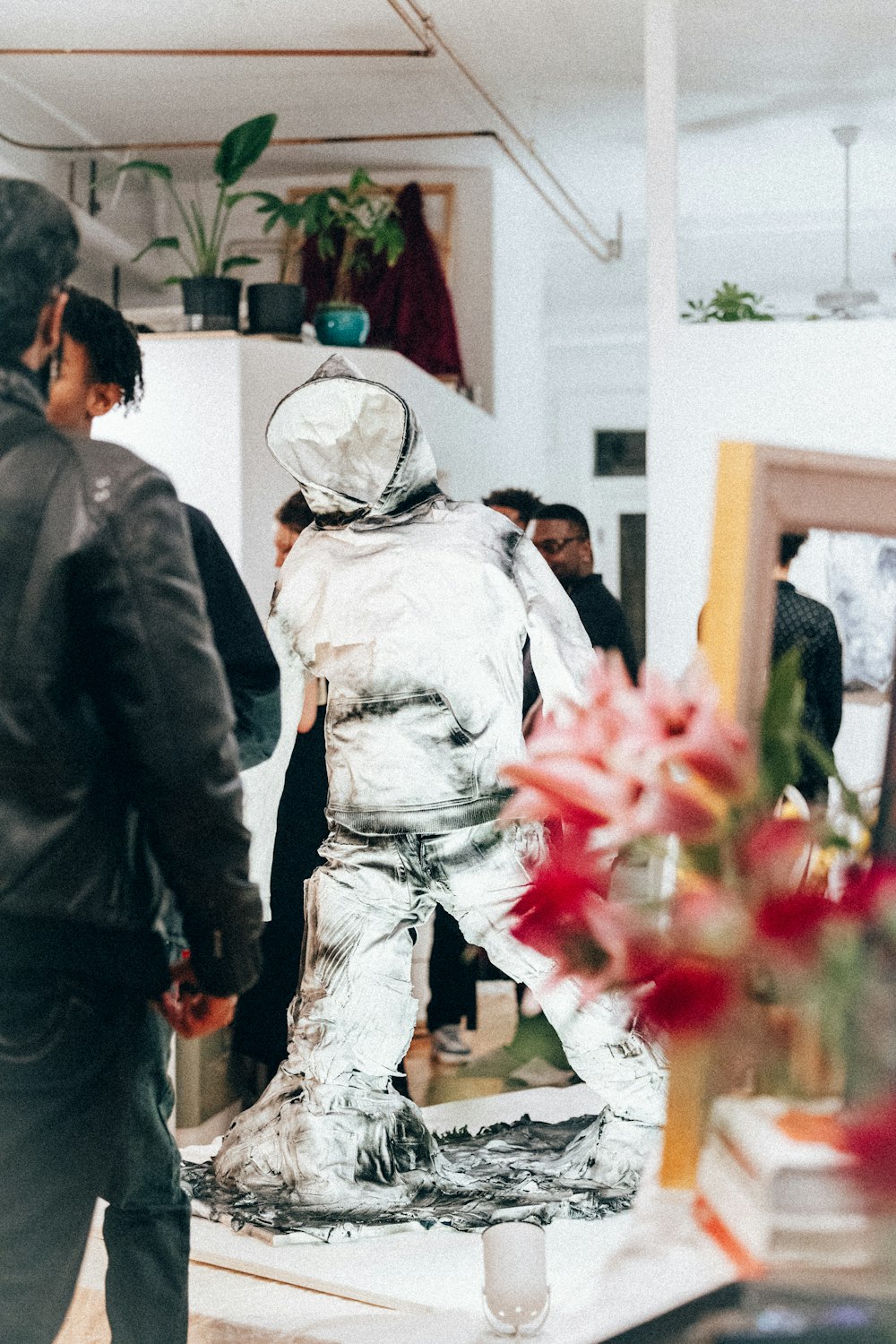 a group of people standing around a silver statue