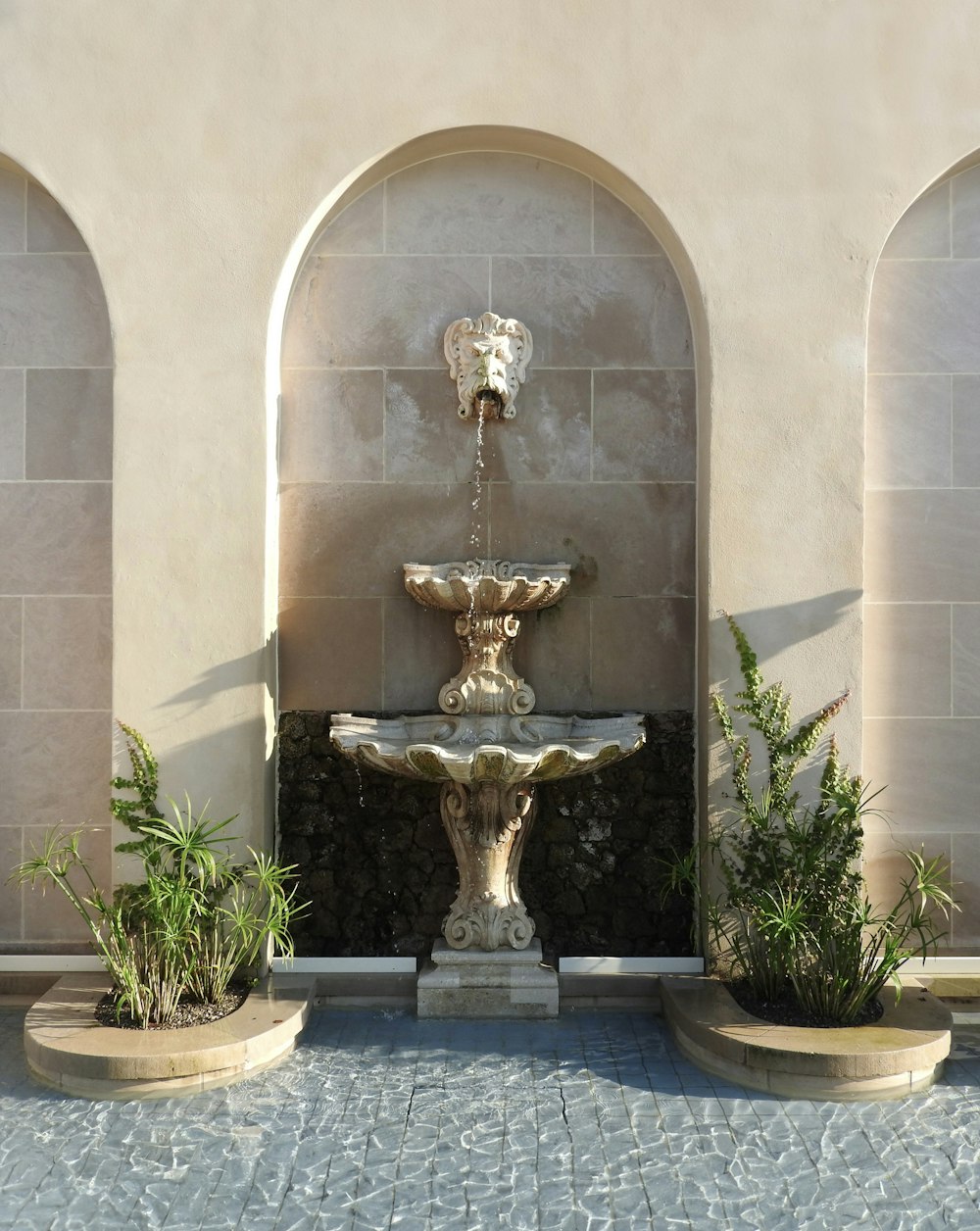 a fountain in a courtyard surrounded by arches