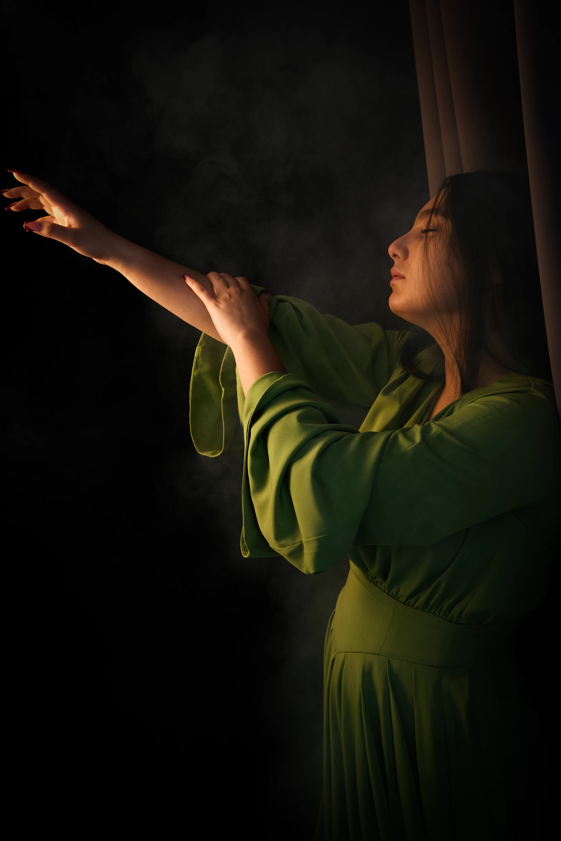 a woman in a green dress holding out her hand