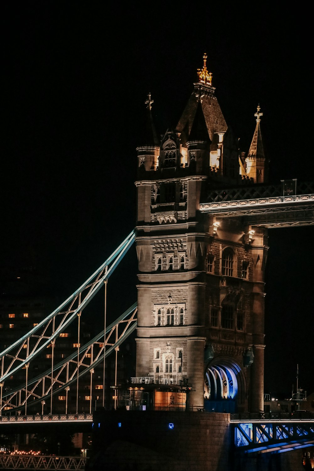 the tower bridge is lit up at night