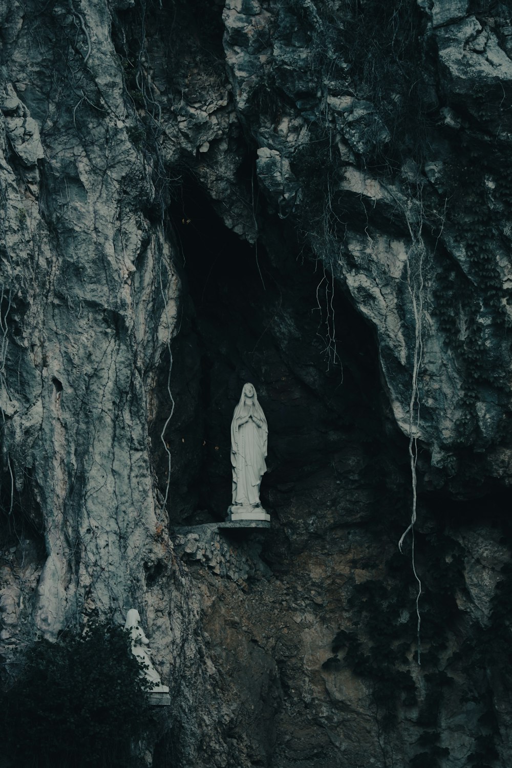 a statue of a person standing in a cave