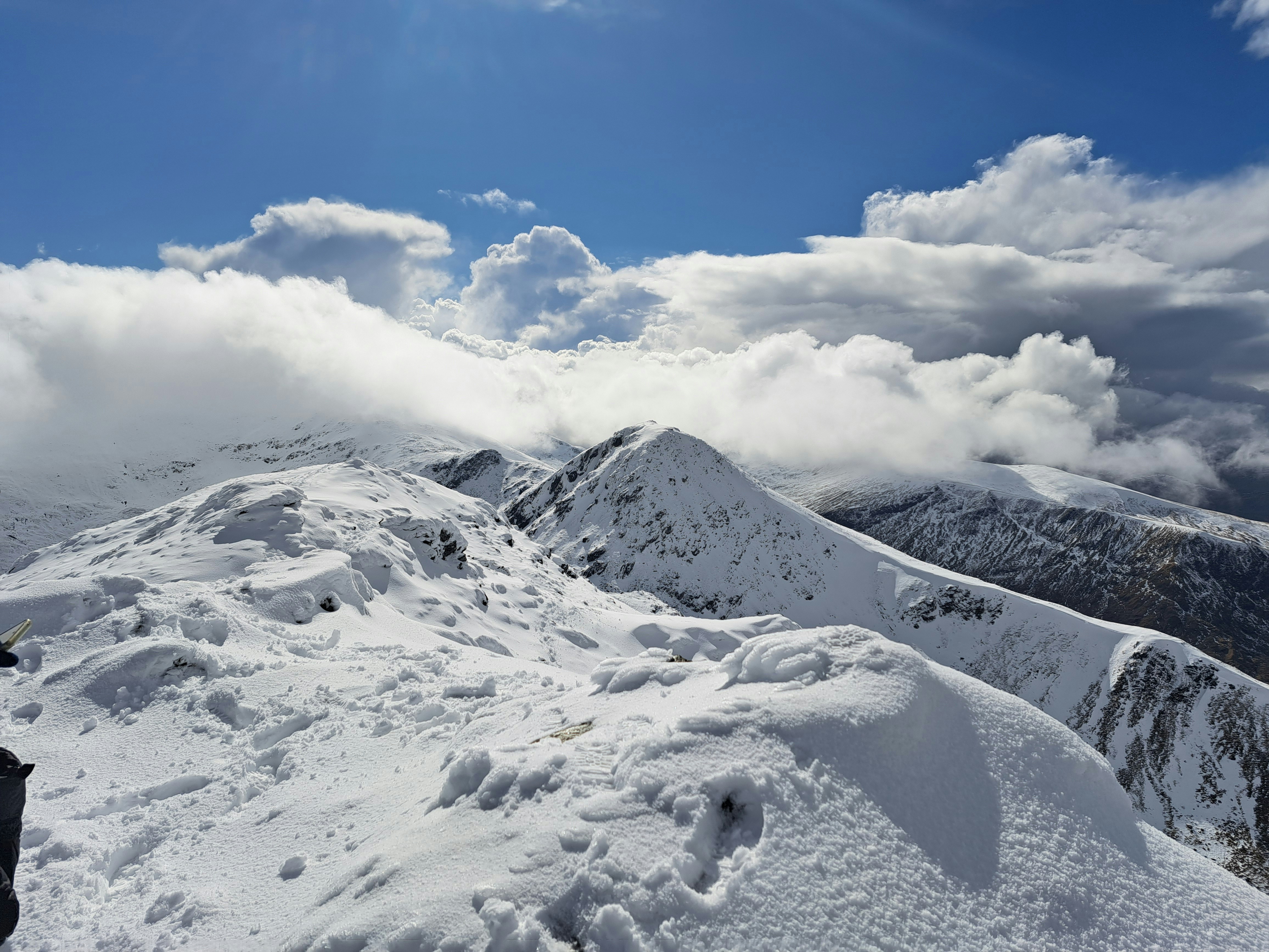 a person standing on top of a snow covered mountain