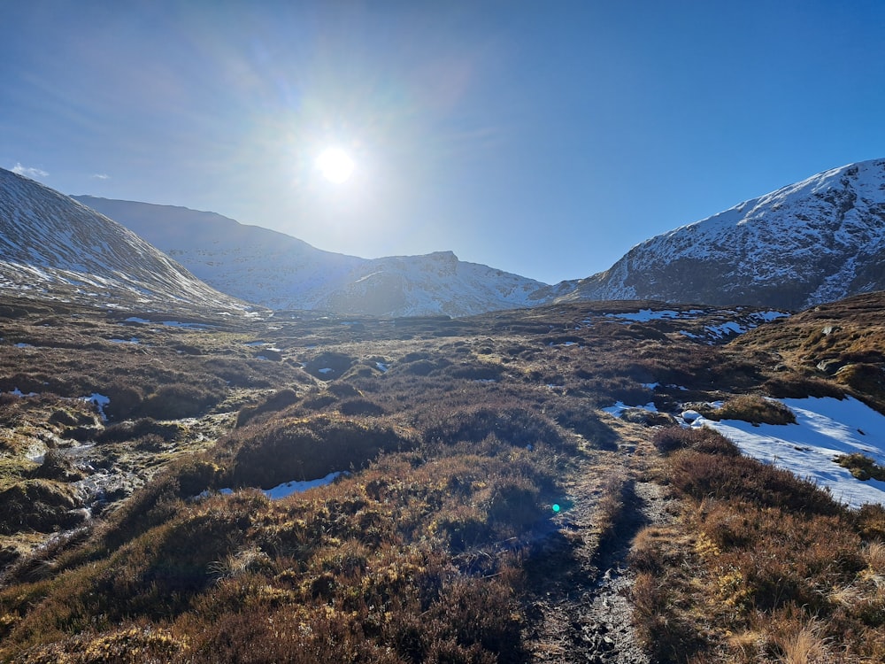 the sun shines brightly over a snowy mountain range