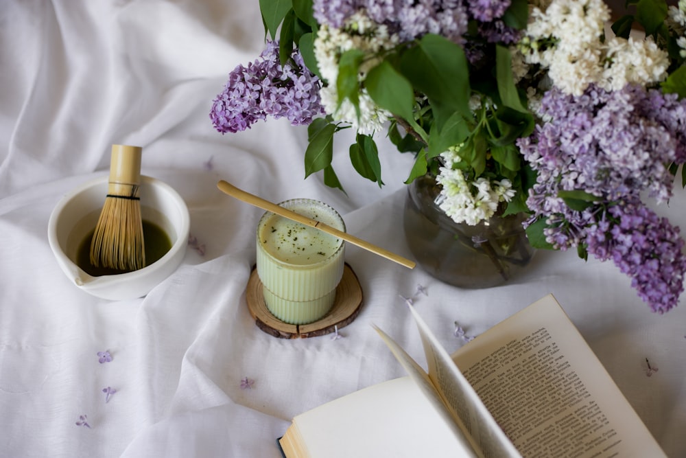 a vase of flowers and a whisk on a table