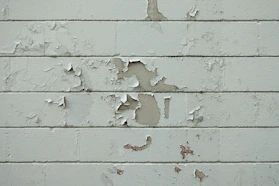 a white brick wall with peeling paint on it