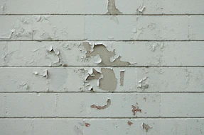 a white brick wall with peeling paint on it