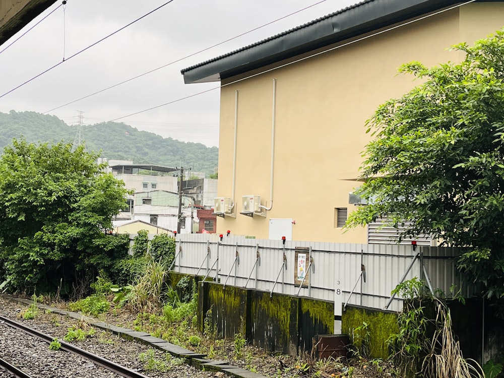 a train track with a building and trees in the background