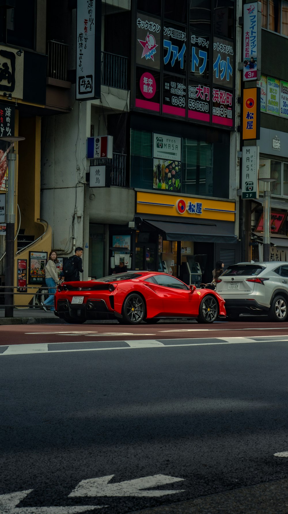 un'auto sportiva rossa parcheggiata sul ciglio della strada