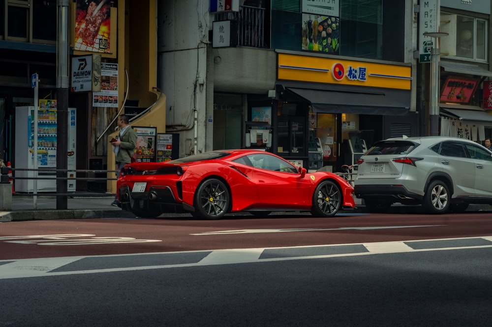 un'auto sportiva rossa parcheggiata accanto a un'auto bianca