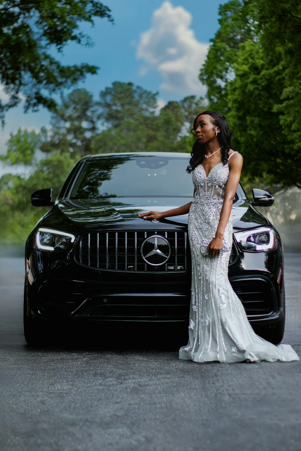 a woman standing next to a black car