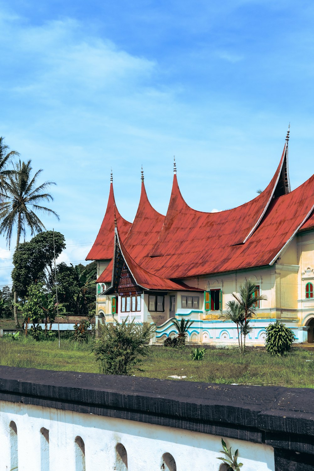 a building with a red roof and a white fence