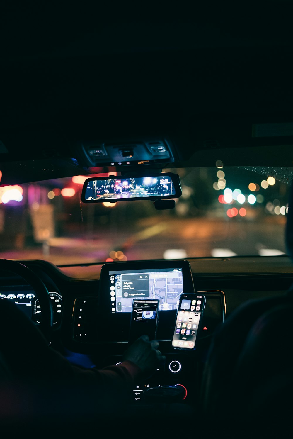 a man driving a car at night in the city