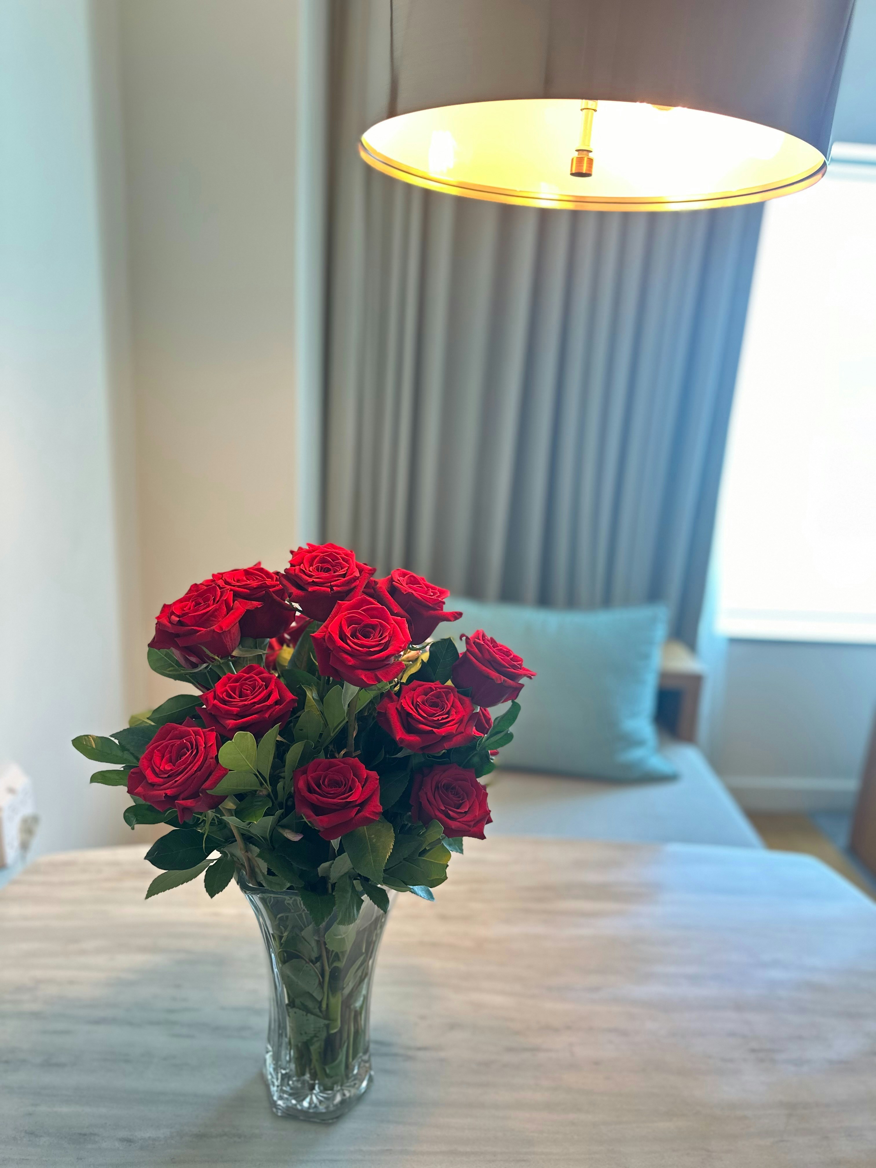 a vase of red roses sitting on a table