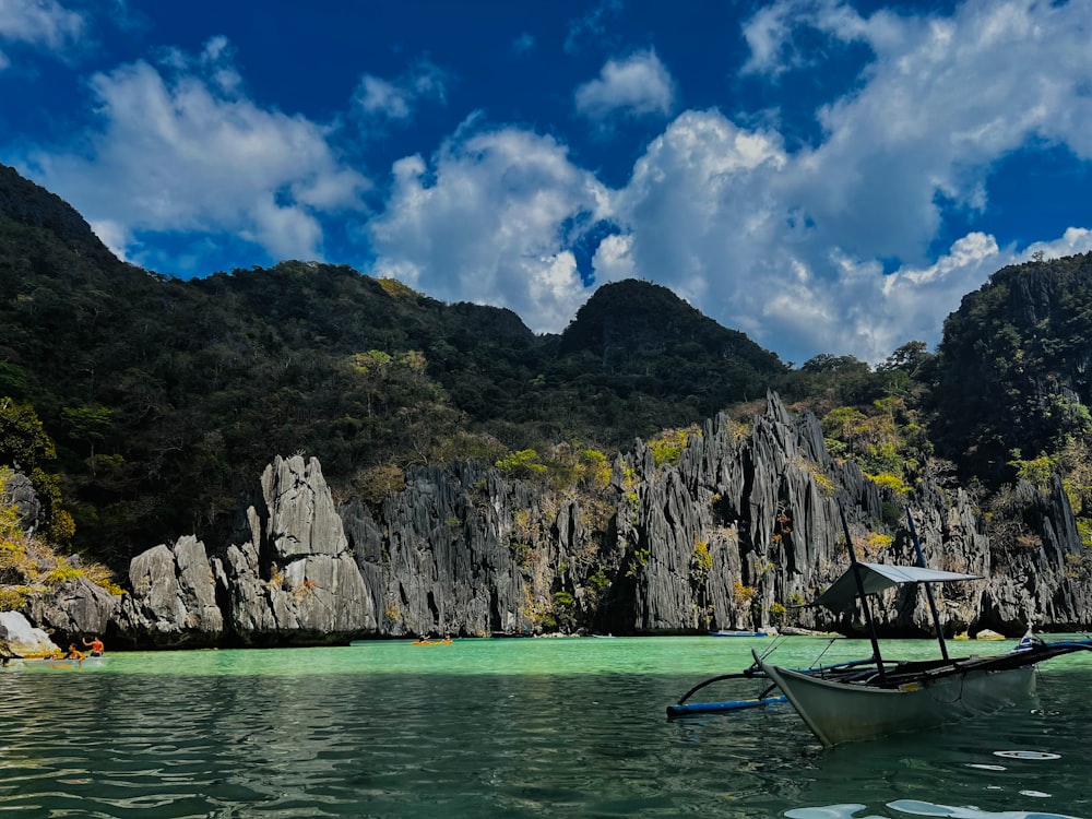 a boat floating on top of a lake surrounded by mountains