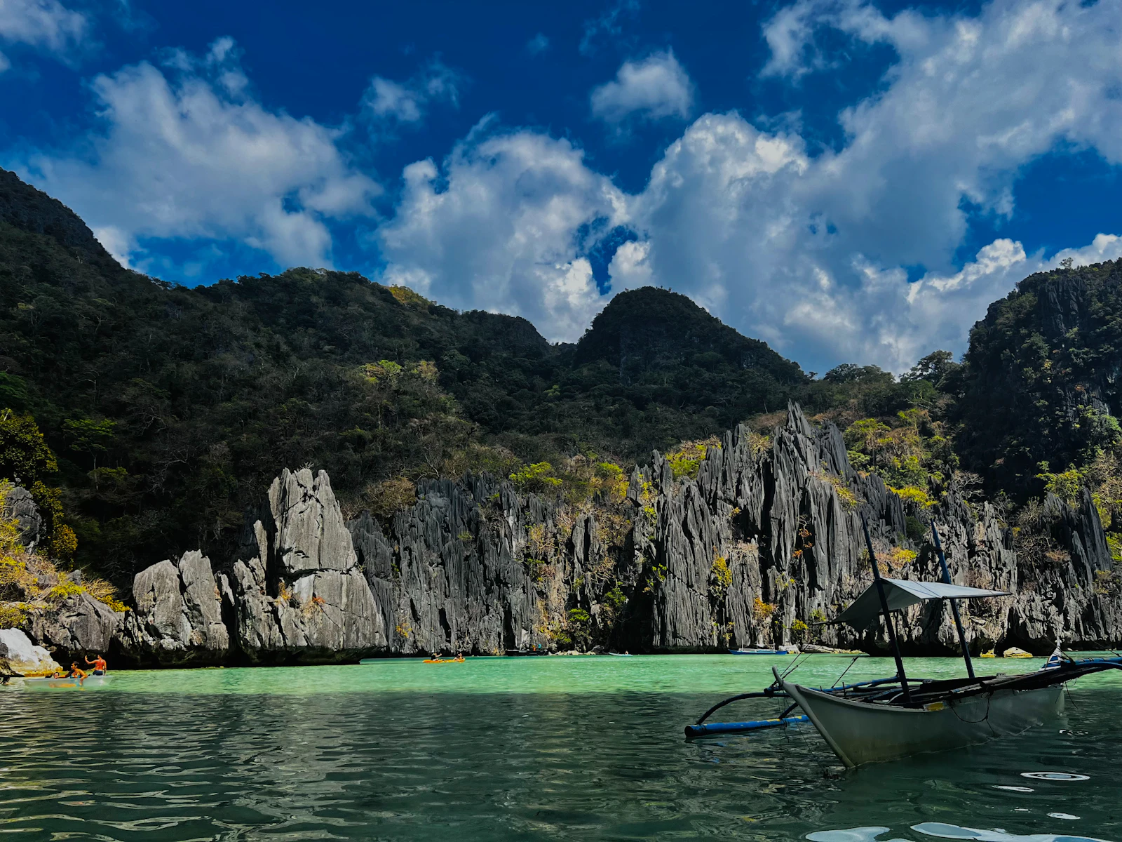Limestone karsts and an outrigger boat in a Palawan lagoon