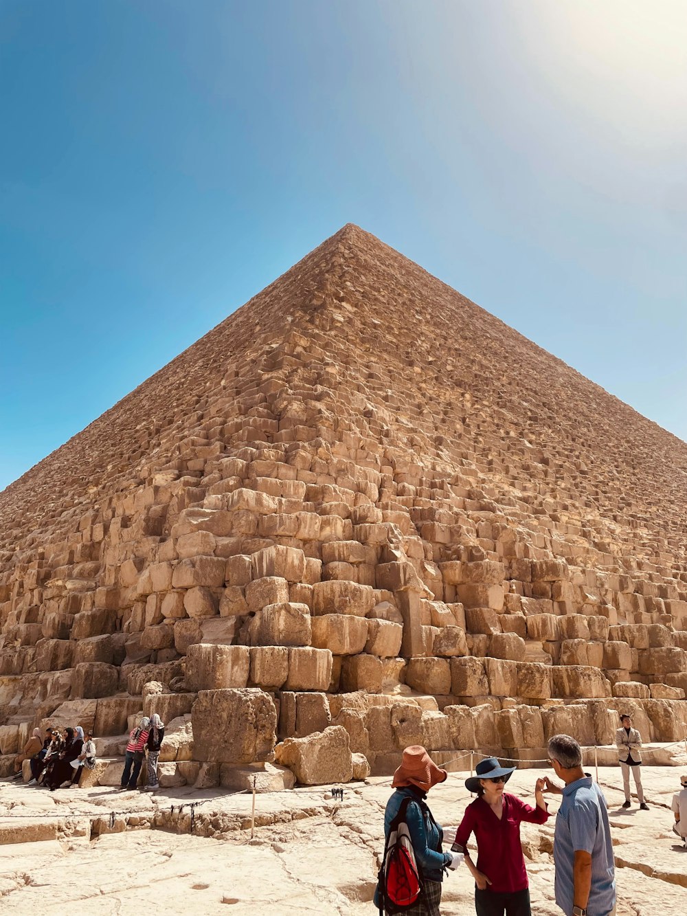 a group of people standing in front of a large pyramid