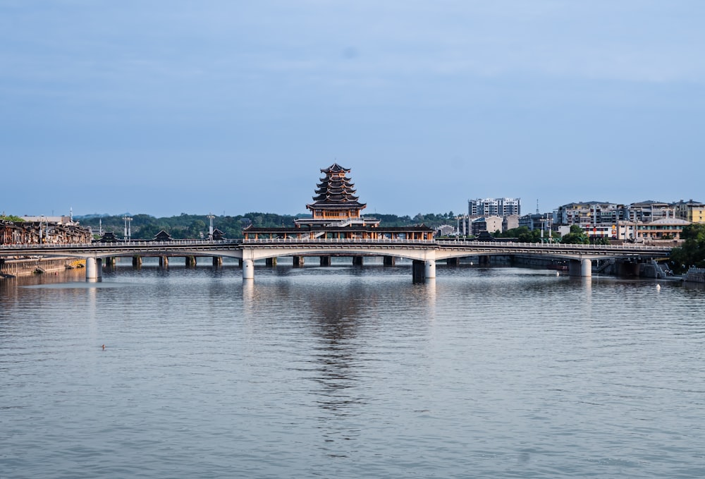 a bridge over a body of water with buildings in the background