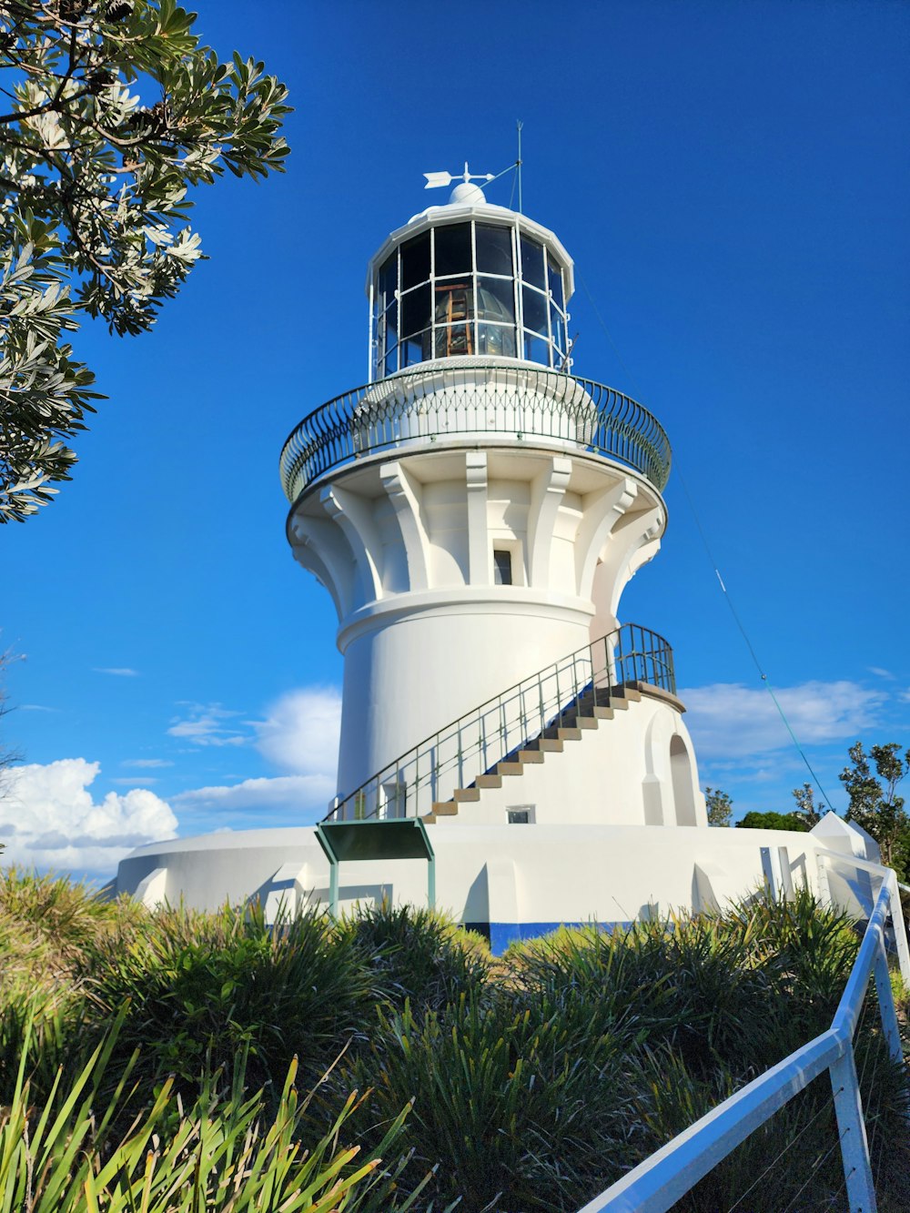 a white lighthouse with a blue sky in the background