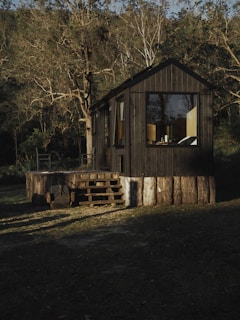a small wooden cabin with a porch and stairs
