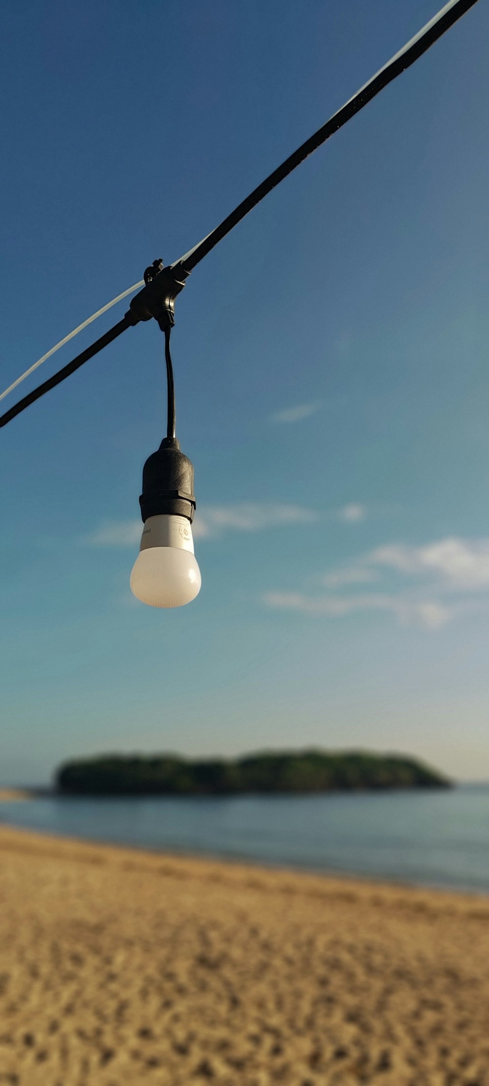 a light that is hanging from a wire on a beach