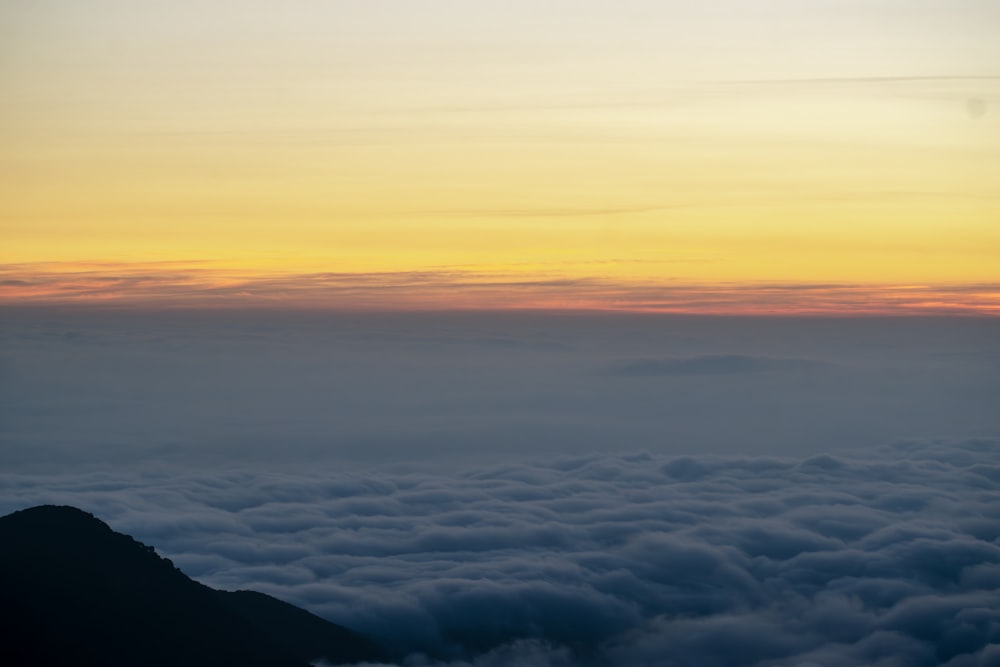 the sun is setting over the clouds in the sky