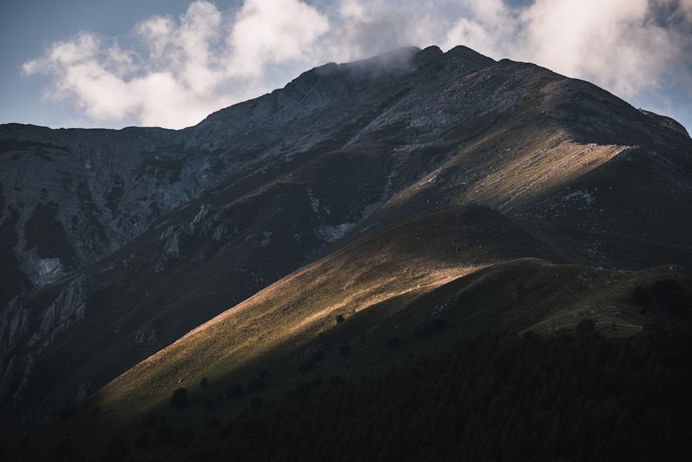 a view of a mountain with clouds in the sky