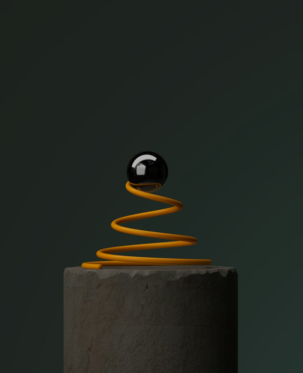 a black object sitting on top of a cement pillar