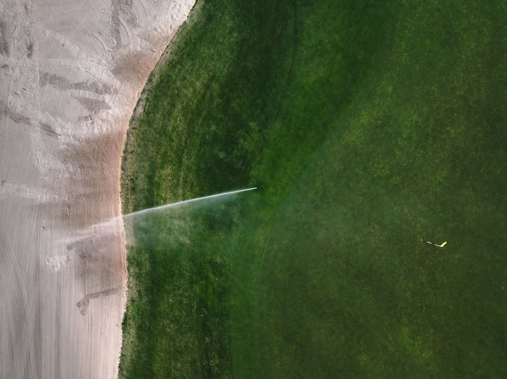 an aerial view of a golf course with a water sprinkler