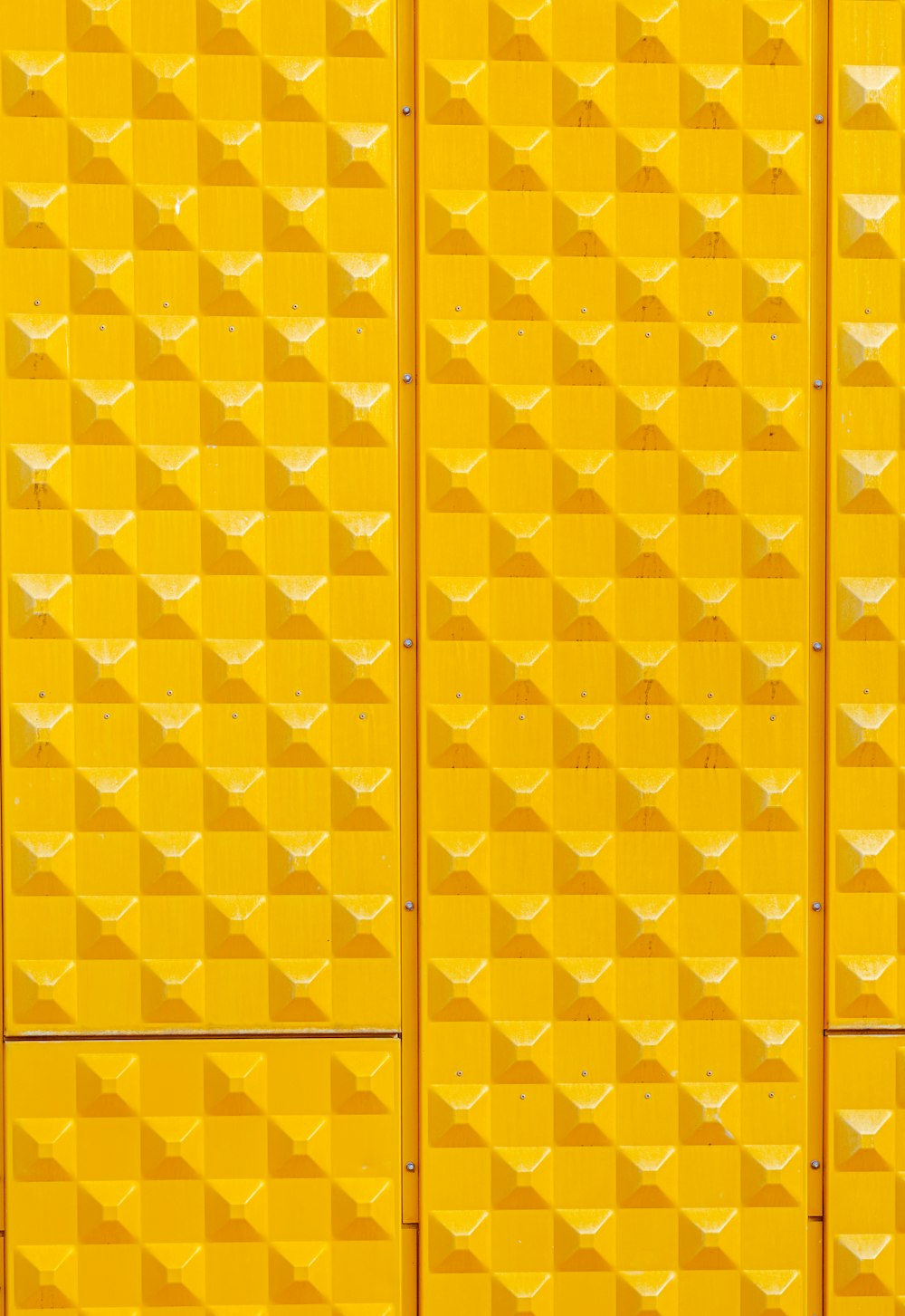 a yellow wall that has a bunch of squares on it