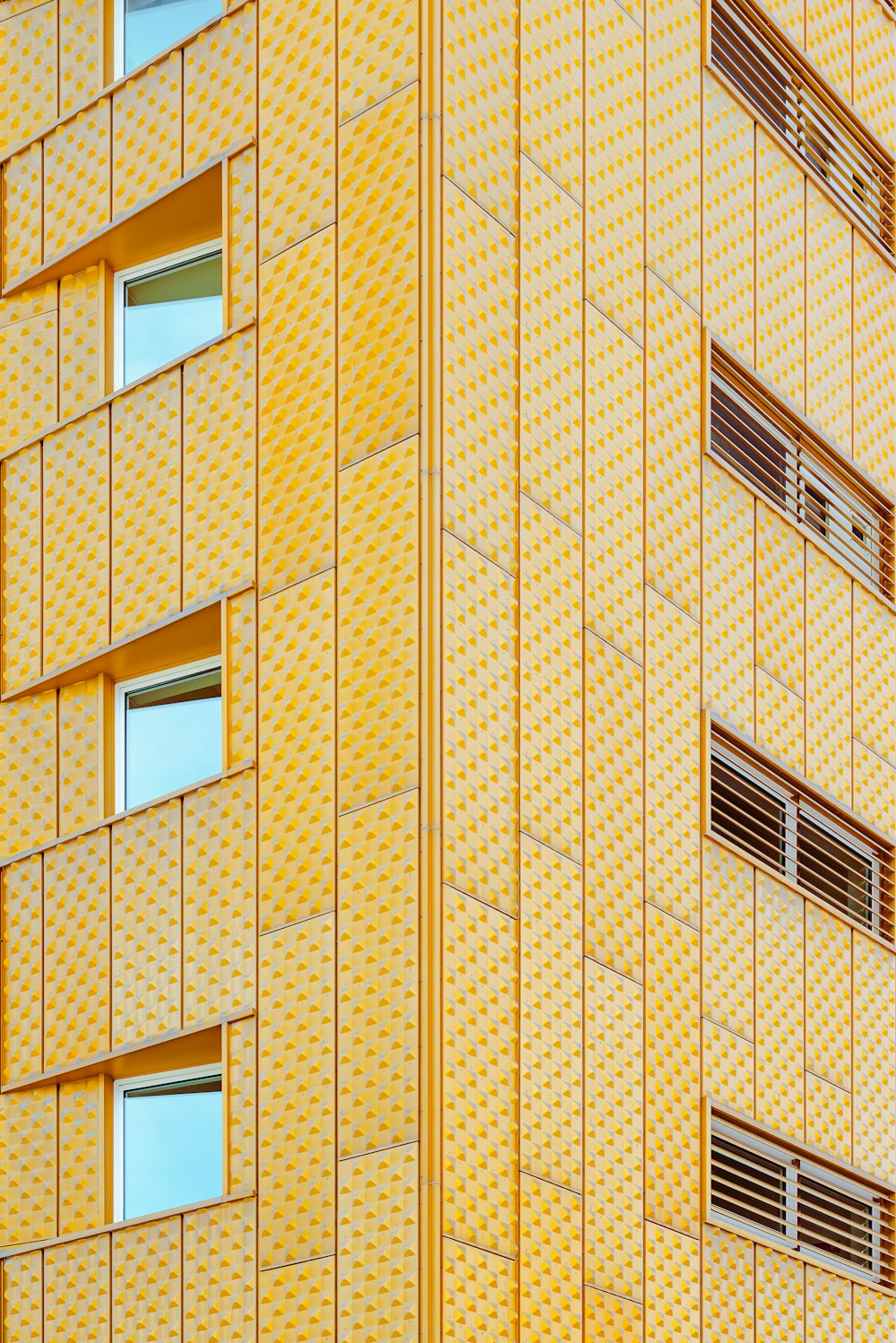 a tall yellow building with a clock on the side of it