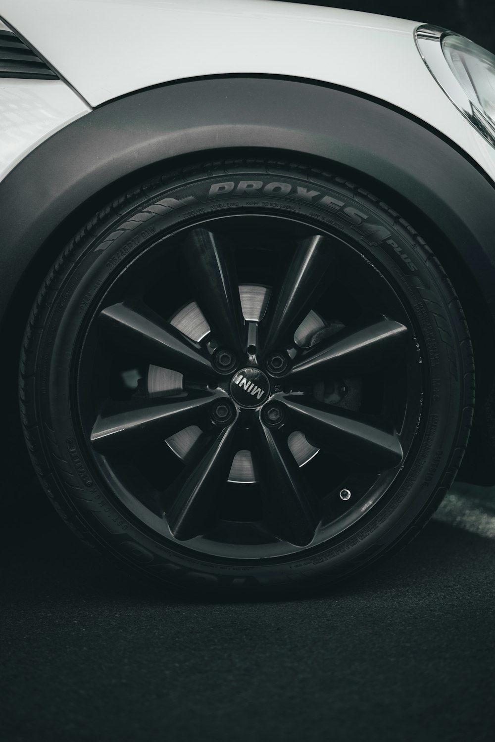 a black and white photo of a car wheel
