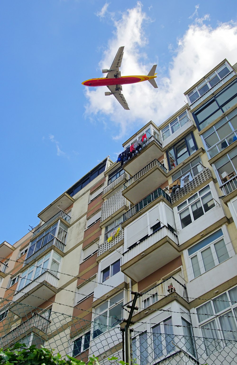 an airplane flying over a building with balconies