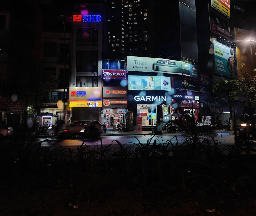 a city street at night with a lot of neon signs